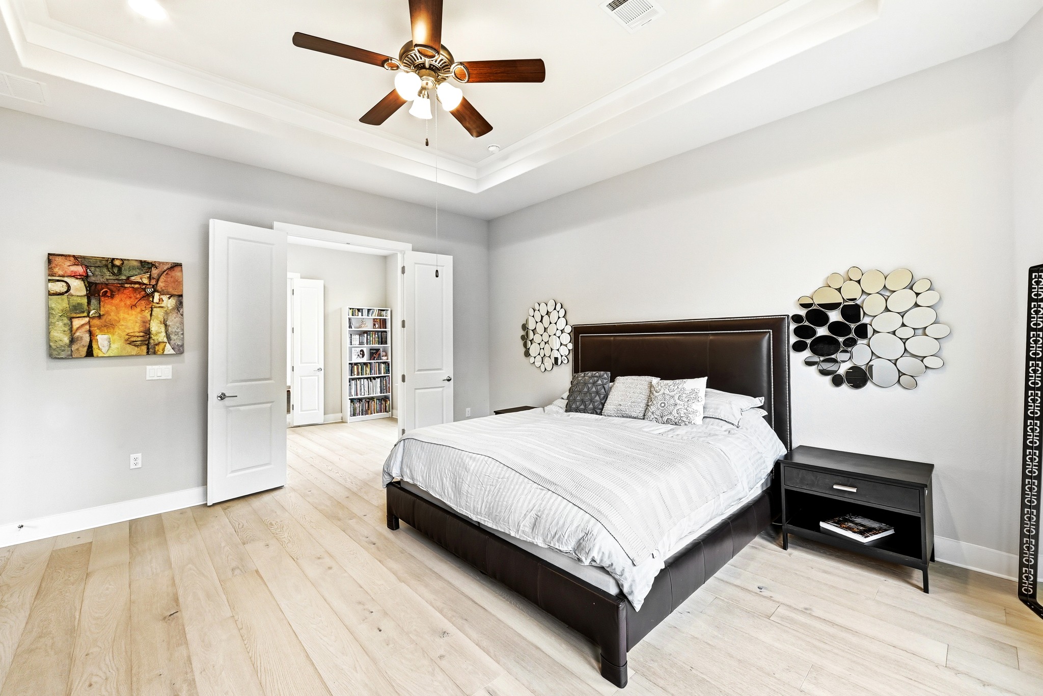 9008 Harper Rae Drive Austin, TX 78717 - Photo 18 of 39 Spacious room featuring light wood-finish flooring, a tray ceiling with a ceiling fan, and double doors opening to another area