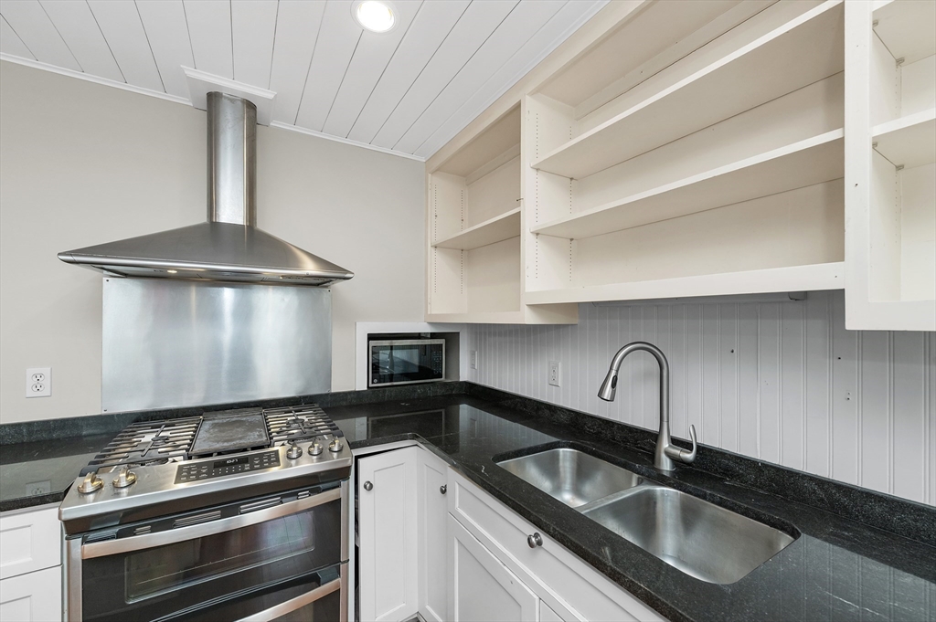 18 Bennett Street, Unit 2 Manchester, MA 01944 - Photo 1 of 21 a kitchen with granite countertop a sink stainless steel appliances and cabinets