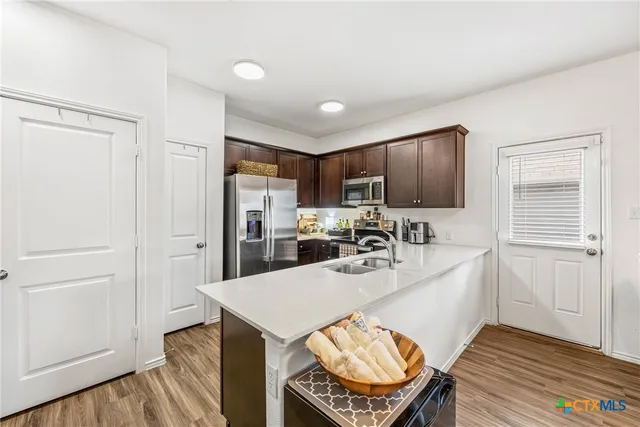 a kitchen with stainless steel appliances granite countertop a sink refrigerator and cabinets