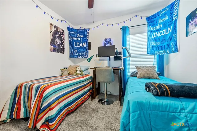 a bedroom with a bed and a lamp on dresser