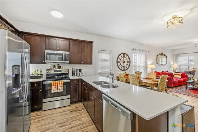 a kitchen with granite countertop stainless steel appliances a stove and a refrigerator