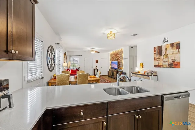 a kitchen with kitchen island a sink and a stove with wooden floor