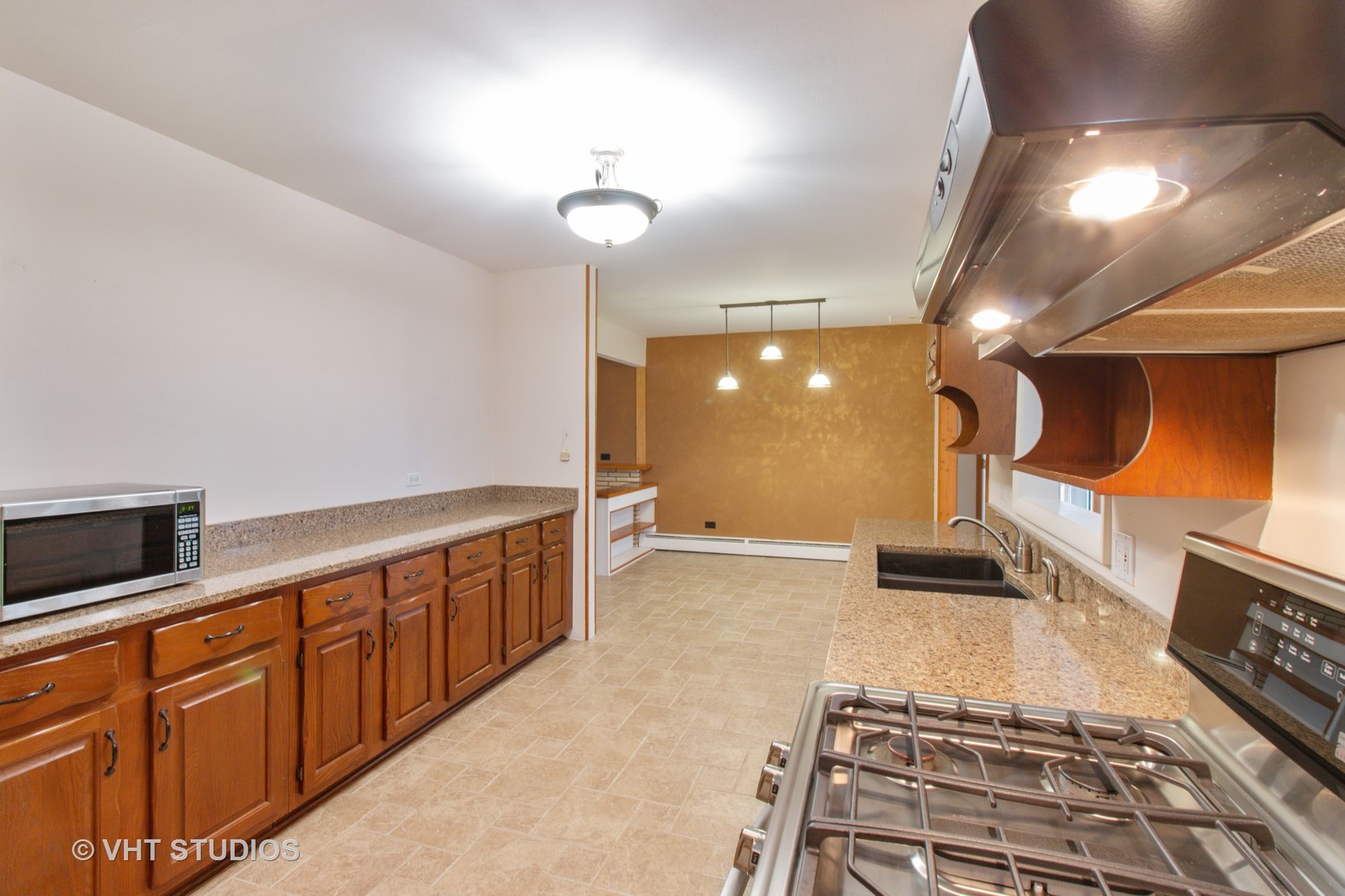 708 Hickory Road Woodstock, IL 60098 - Photo 7 of 22 a large room with lots of counter space and wooden floor