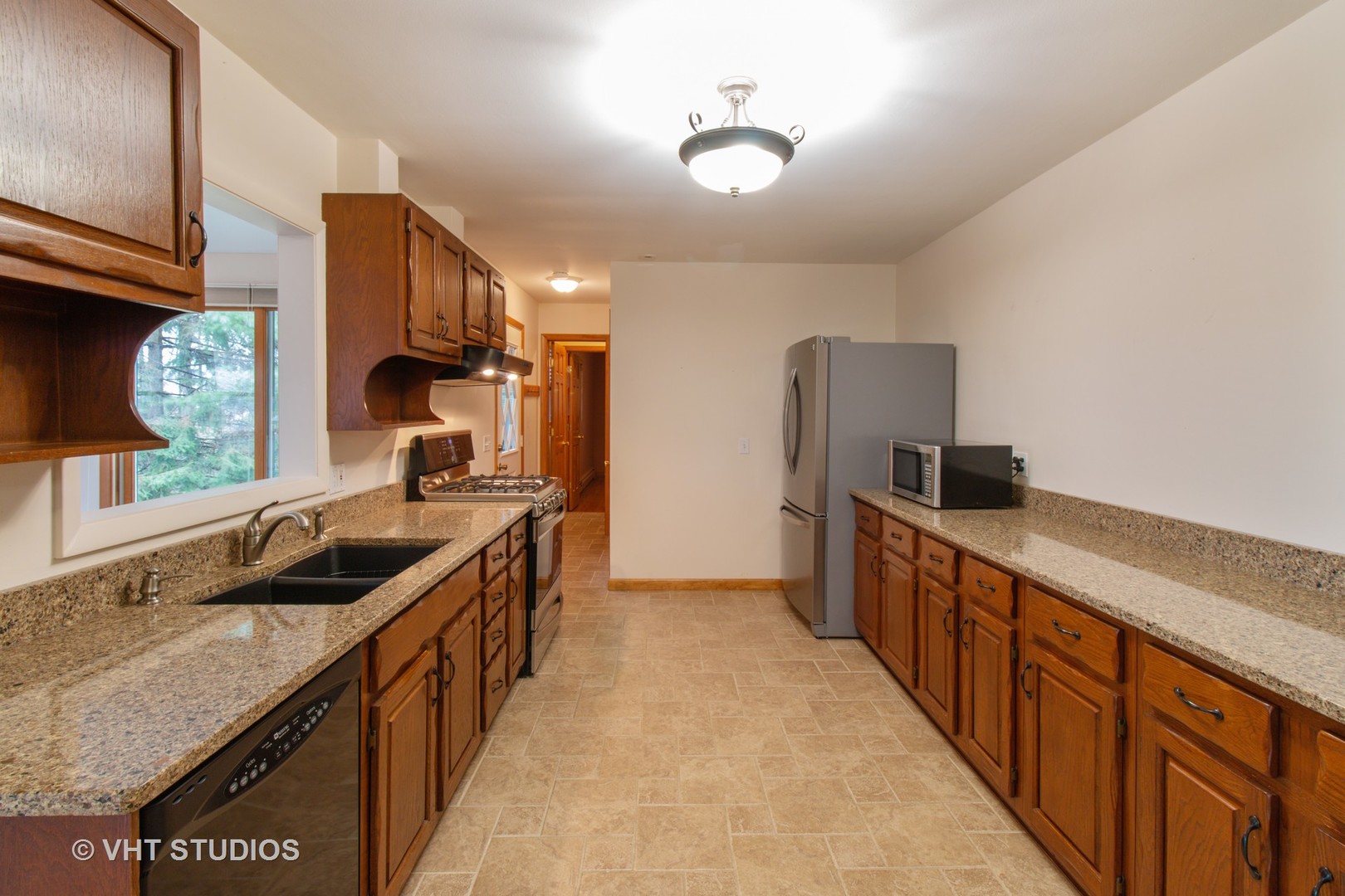 708 Hickory Road Woodstock, IL 60098 - Photo 9 of 22 a kitchen with stainless steel appliances granite countertop a sink and a refrigerator
