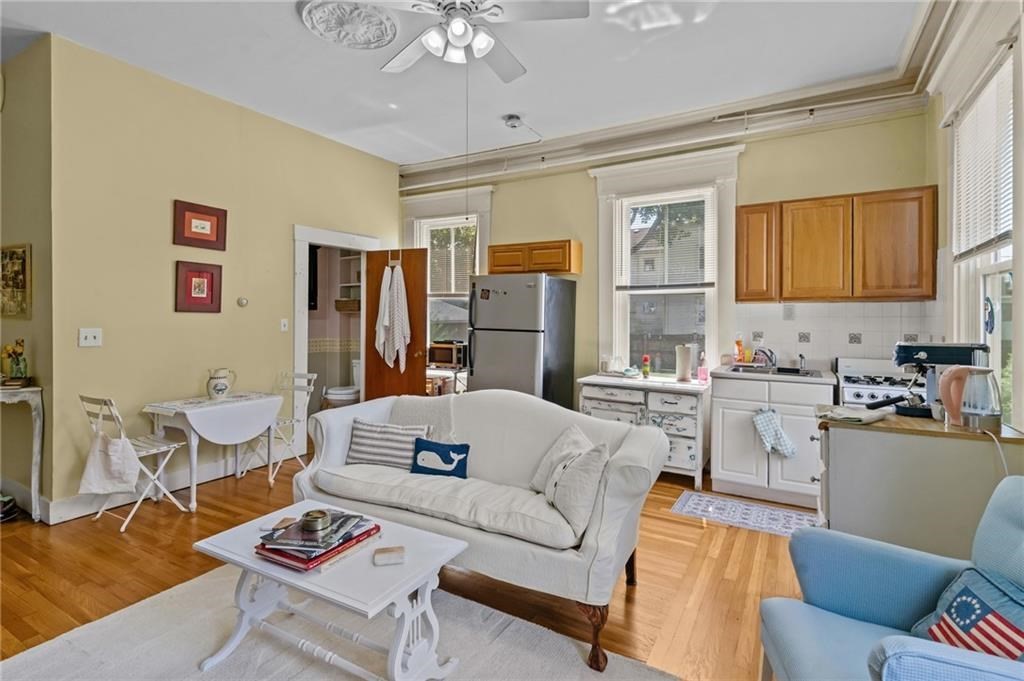 21 Federal Street Warren, RI 02885 - Photo 5 of 27 a living room with furniture a dining table and a chandelier