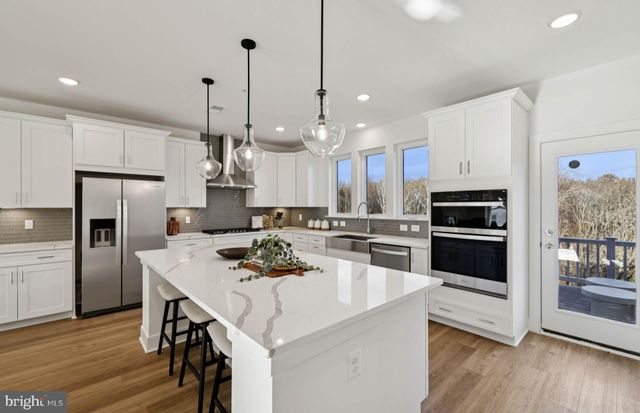 a kitchen with kitchen island a stove a table and chairs