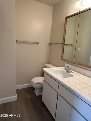 a bathroom with a granite countertop sink toilet and a mirror