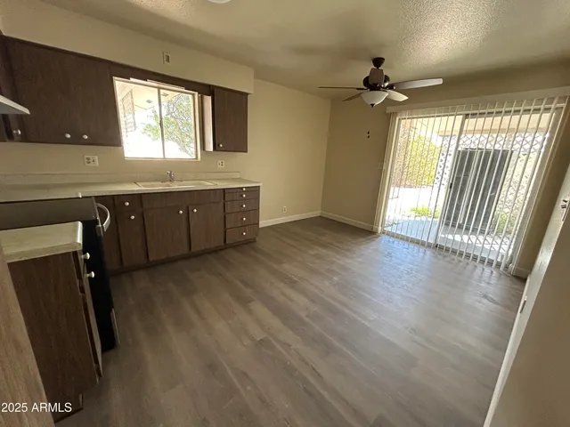 a open kitchen with wooden floor and a window