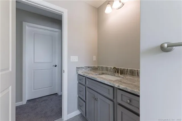 a bathroom with a granite countertop sink and mirror