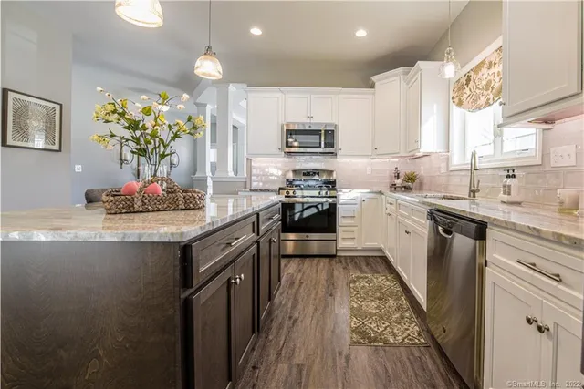 a kitchen with stainless steel appliances granite countertop a sink stove and refrigerator