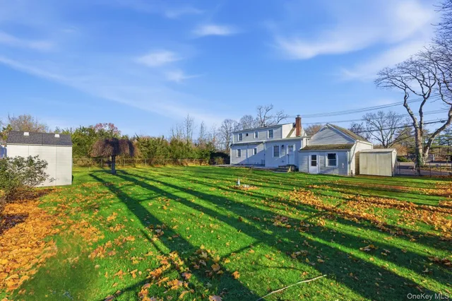a view of a big house with a big yard and large trees