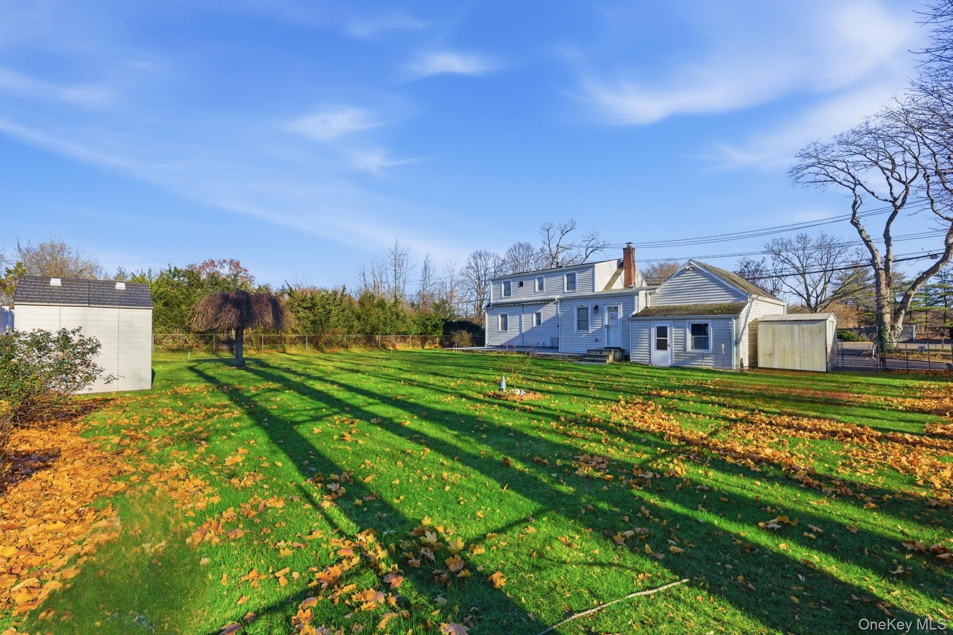 1547 Walt Whitman Road Melville, NY 11747 - Photo 20 of 25 a view of a big house with a big yard and large trees