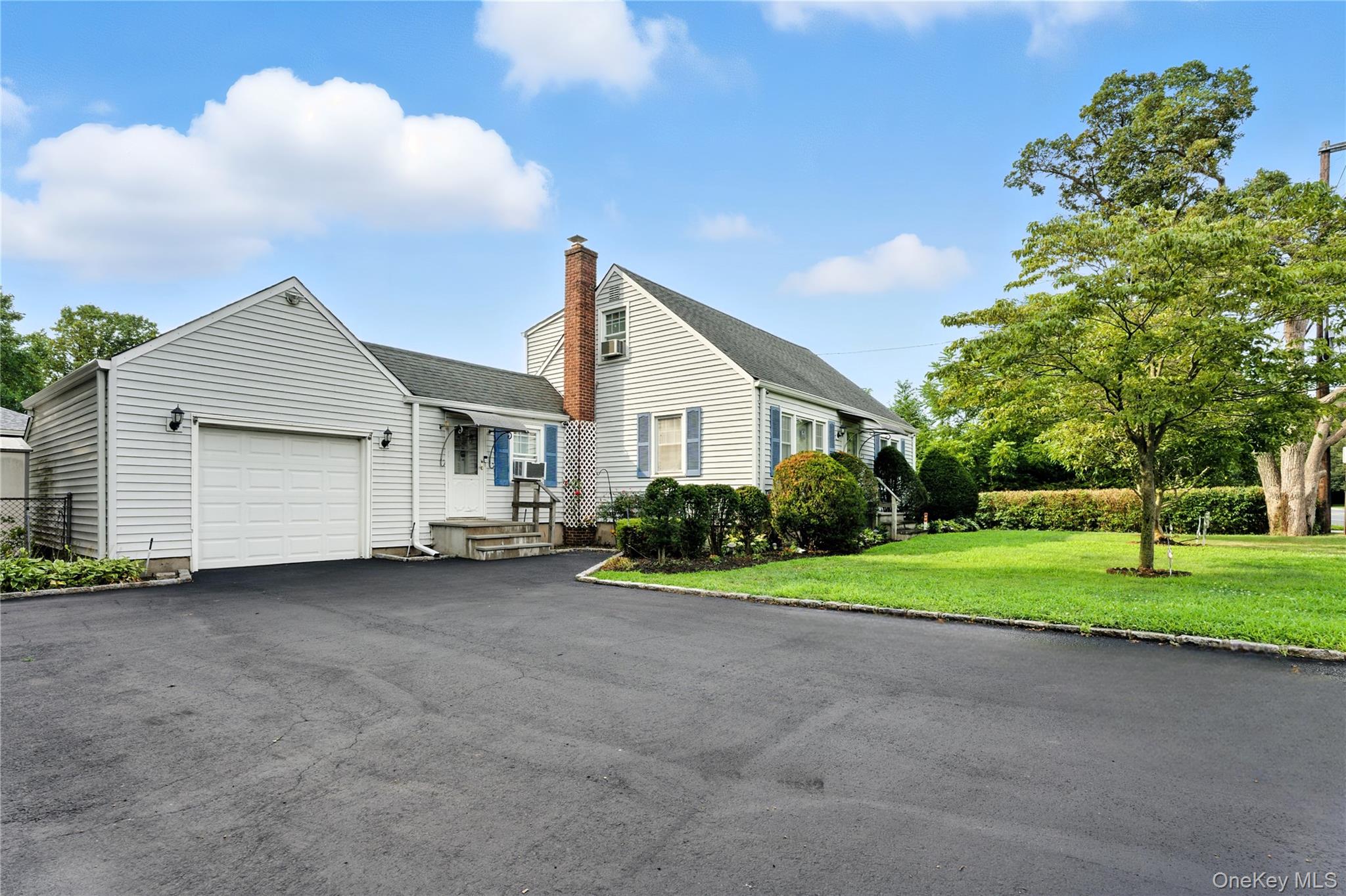 1547 Walt Whitman Road Melville, NY 11747 - Photo 2 of 25 a view of a house with a yard and garage