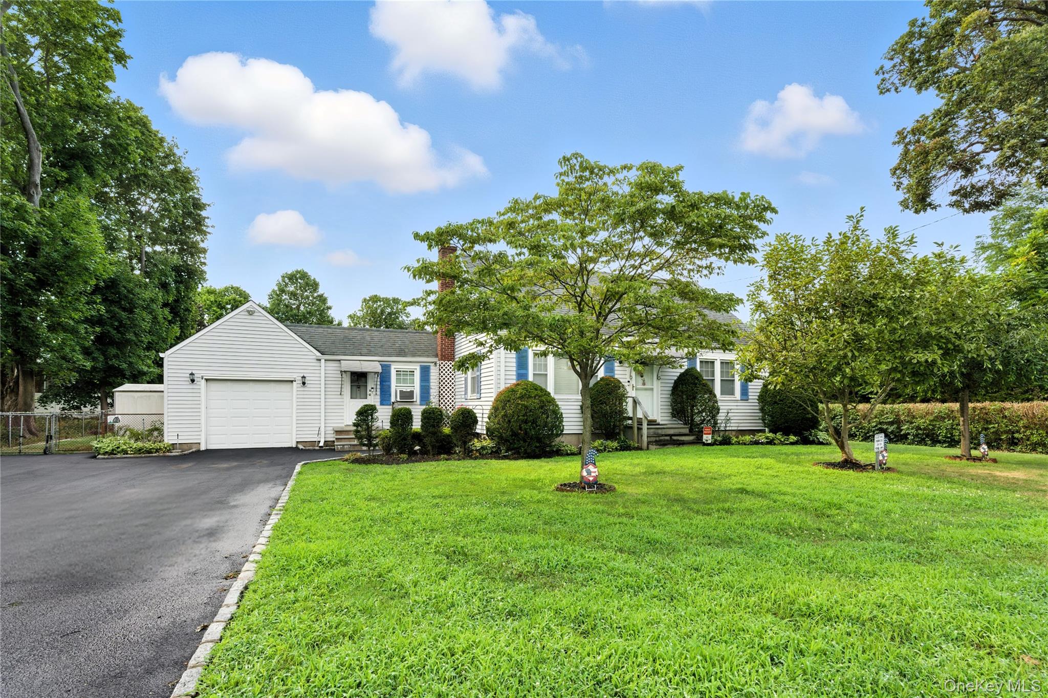 1547 Walt Whitman Road Melville, NY 11747 - Photo 25 of 25 a front view of a house with a yard and trees