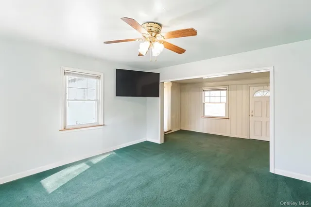 a view of an empty room with closet and a window