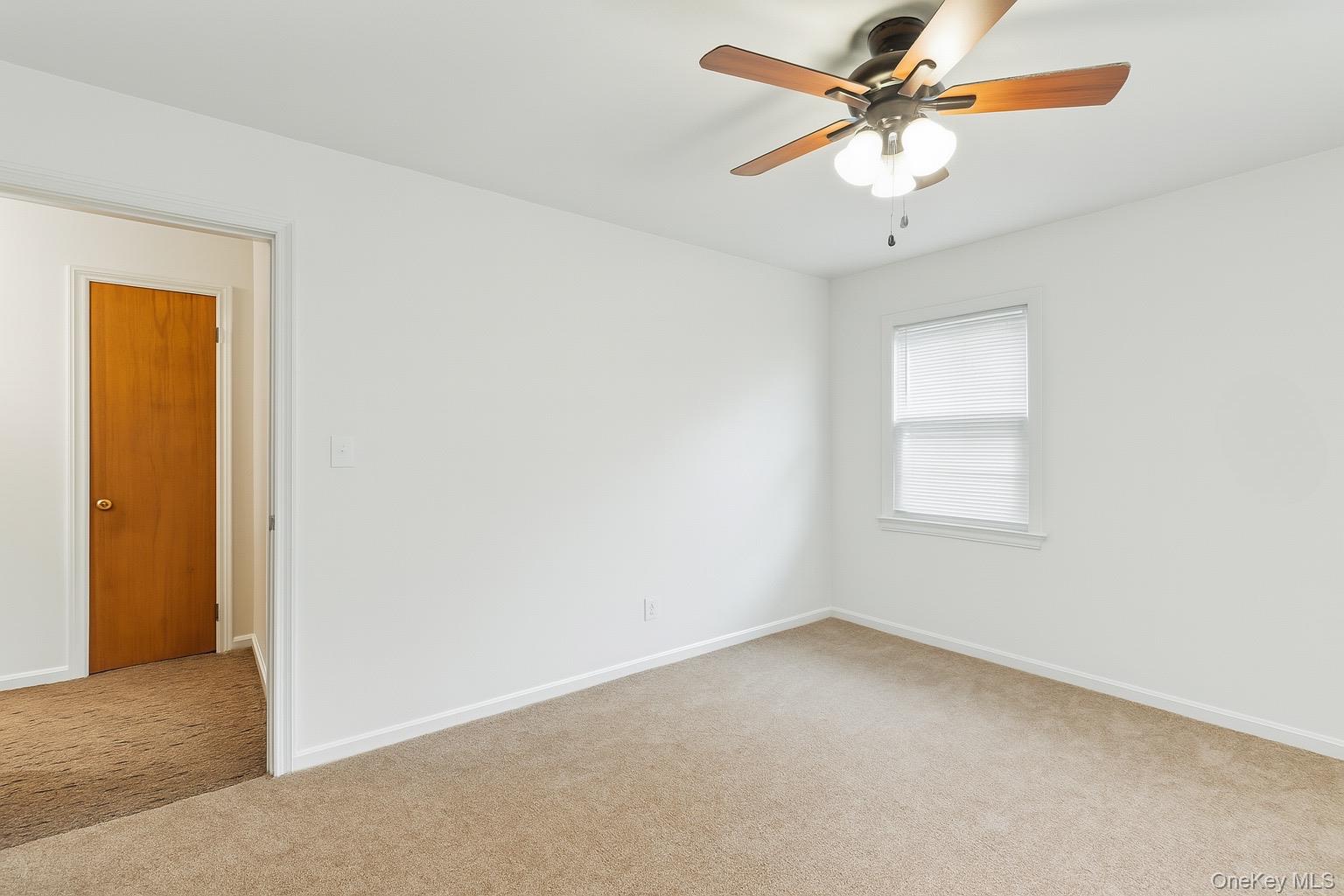 1547 Walt Whitman Road Melville, NY 11747 - Photo 9 of 25 an empty room with a window and a fan