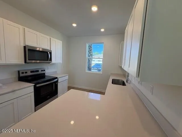 a kitchen with a stove a sink and a microwave