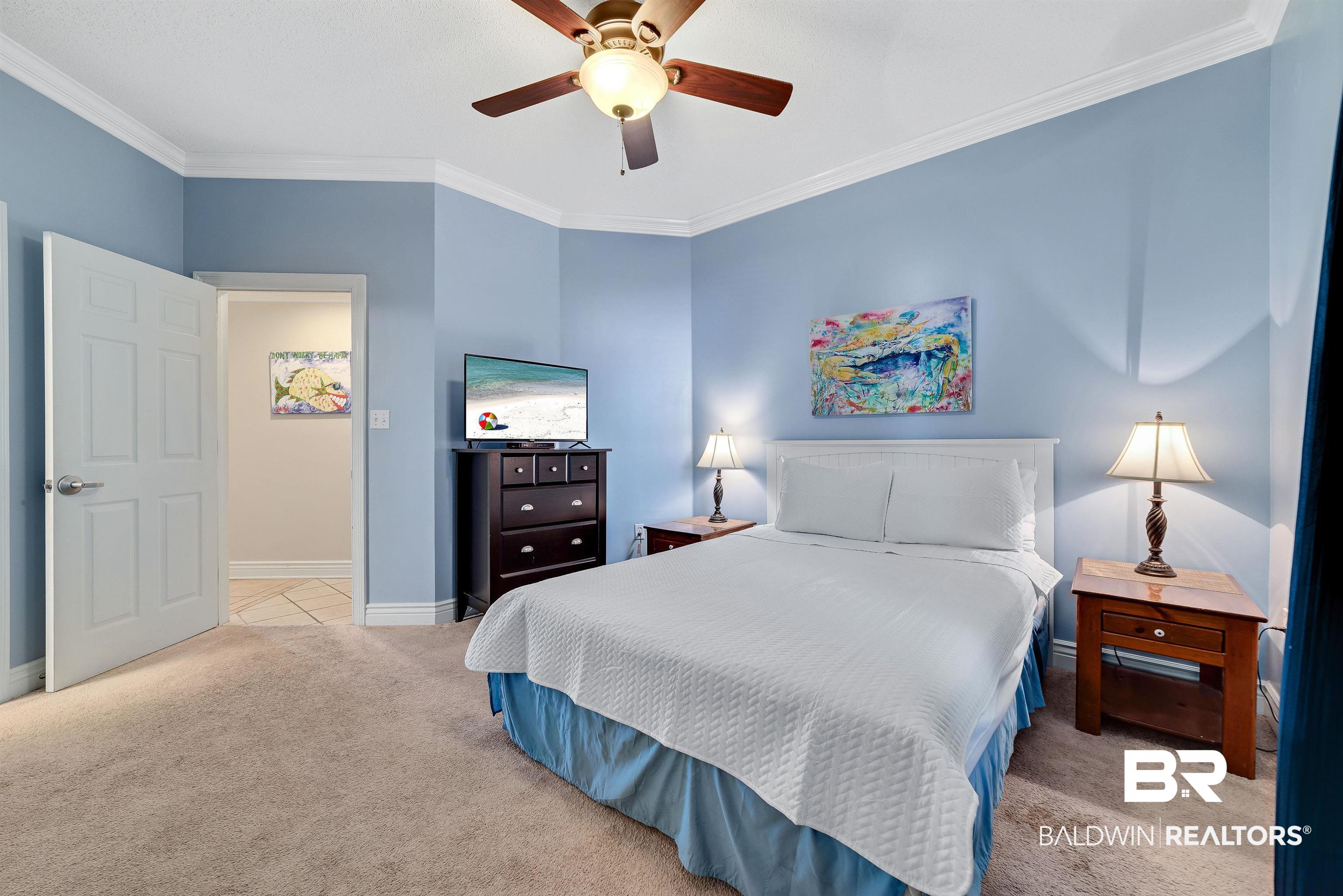 27282 Canal Road, Unit 110 Orange Beach, AL 36561 - Photo 25 of 62 Bedroom featuring light carpet, baseboards, ornamental molding, and ceiling fan