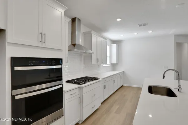 a kitchen with kitchen island a sink stainless steel appliances and cabinets
