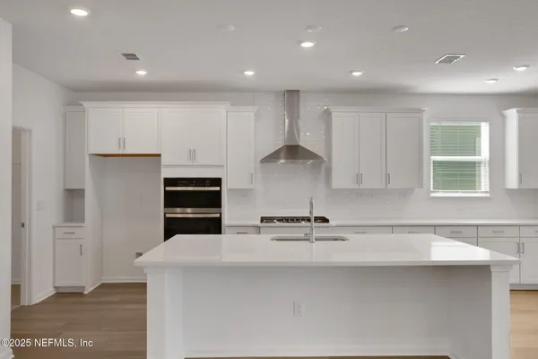 a large kitchen with stainless steel appliances granite countertop a stove a sink and a refrigerator