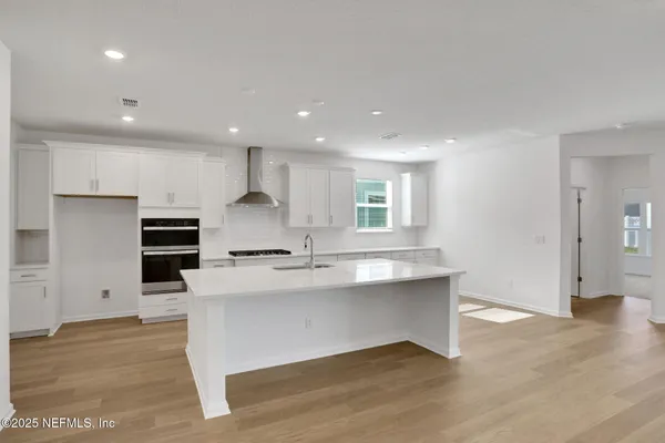 a large kitchen with stainless steel appliances granite countertop a stove a sink and a refrigerator