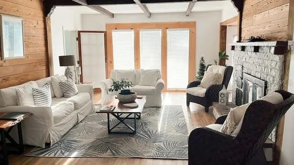 a living room with furniture wooden floor and a large window