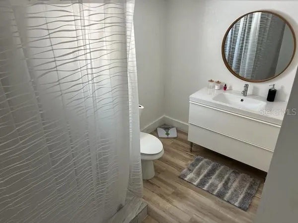 a bathroom with a sink a toilet and a mirror