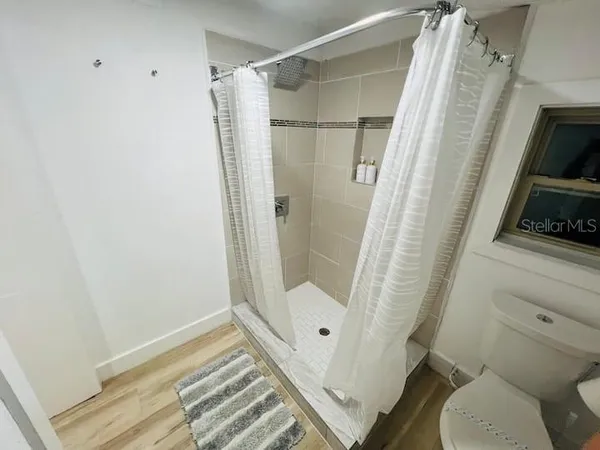 a bathroom with a glass door shower and toilet