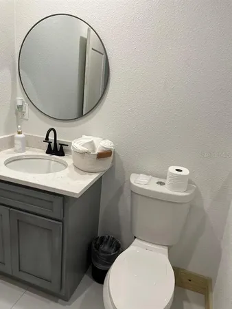 a bathroom with a sink a toilet and a mirror