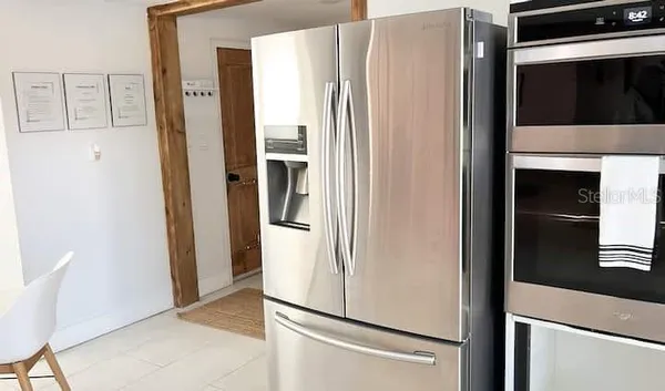 a view of kitchen with stainless steel appliances refrigerator and cabinets