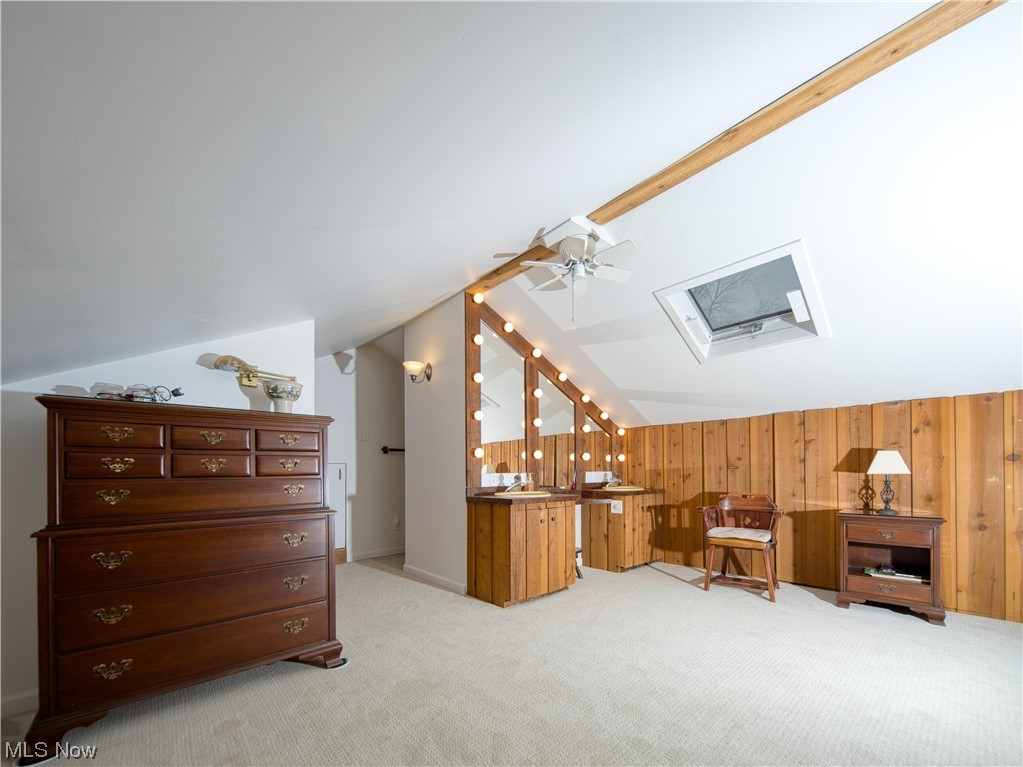9696 Thwing Road Chardon, OH 44024 - Photo 24 of 35 Additional living space with lofted ceiling with skylight, light colored carpet, ceiling fan, and wooden walls and it's own full bathroom