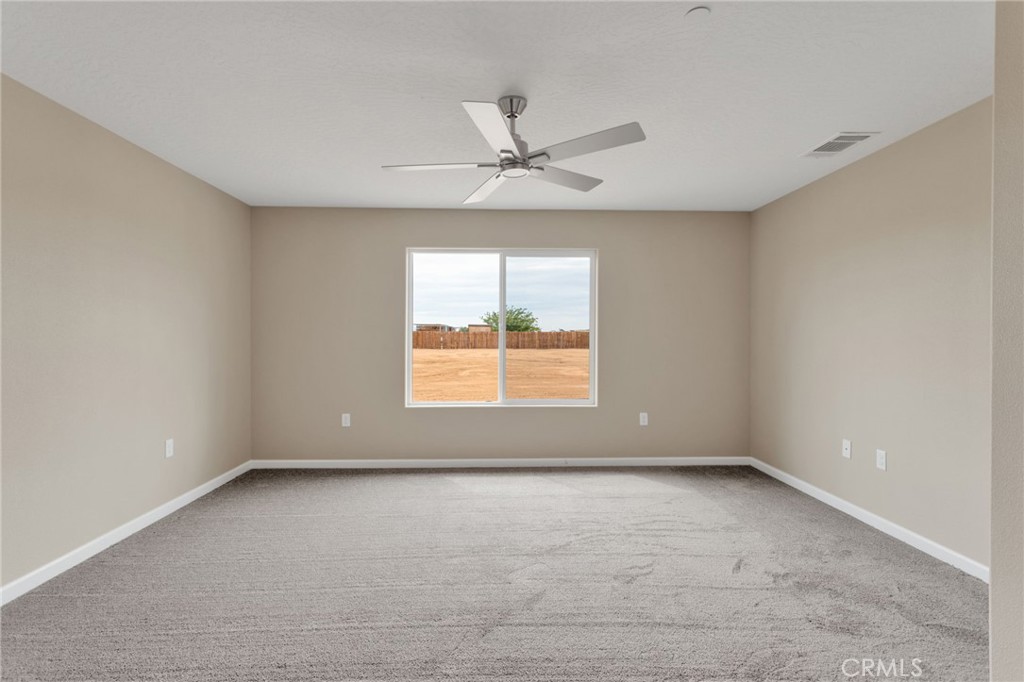 12584 Mesquite Road Apple Valley, CA 92308 - Photo 16 of 44 an empty room with a window and a ceiling fan
