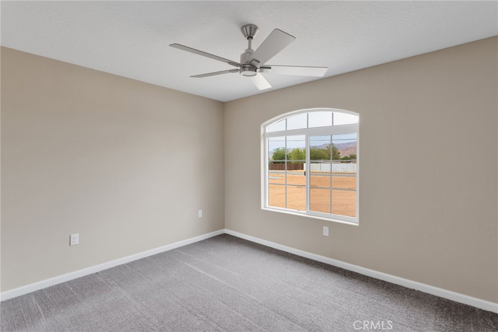 12584 Mesquite Road Apple Valley, CA 92308 - Photo 27 of 44 an empty room with a window and a fan