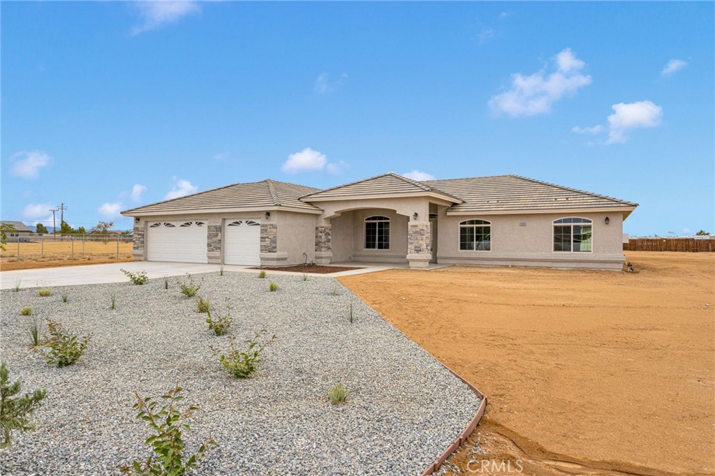 12584 Mesquite Road Apple Valley, CA 92308 - Photo 3 of 44 a front view of a house with a yard