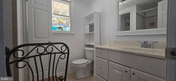 a bathroom with a toilet sink a mirror and a window