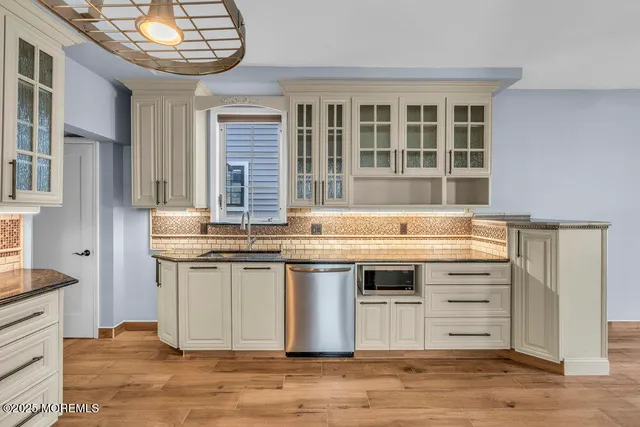 a kitchen with a stove and wooden floor