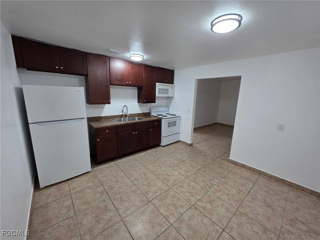 2148 Dora Street, Unit 11 Fort Myers, FL 33901 - Photo 9 of 10 a large kitchen with a refrigerator and a stove