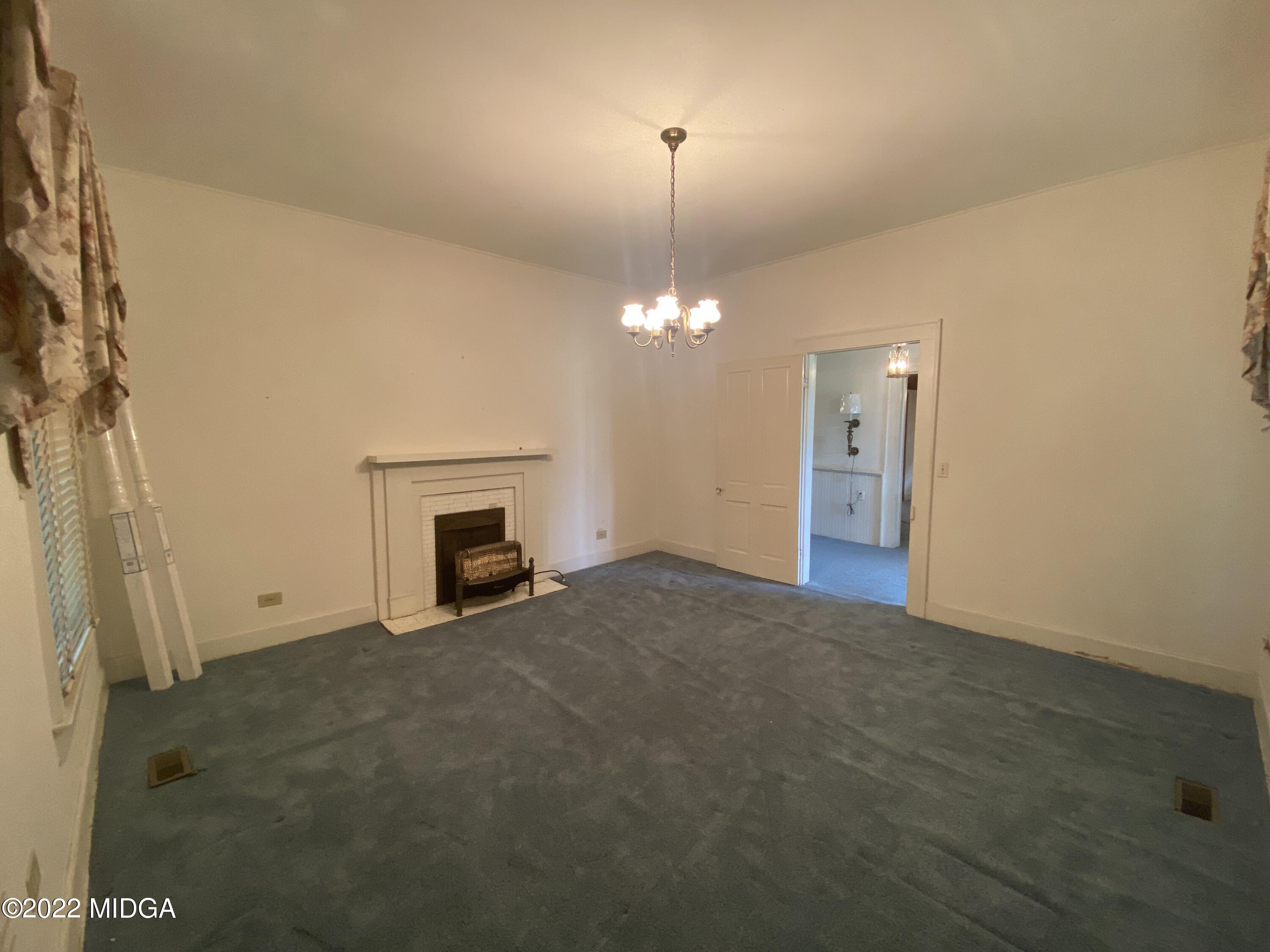 2949 South Lizella Road Lizella, GA 31052 - Photo 4 of 10 a view of a livingroom with a fireplace a chandelier and a window