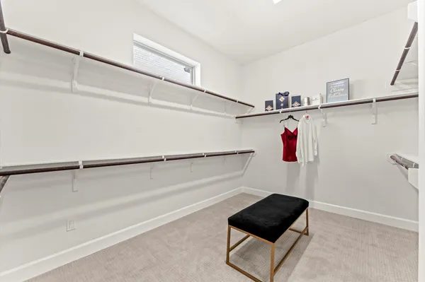 a view of walk in closet with clothes and shoes