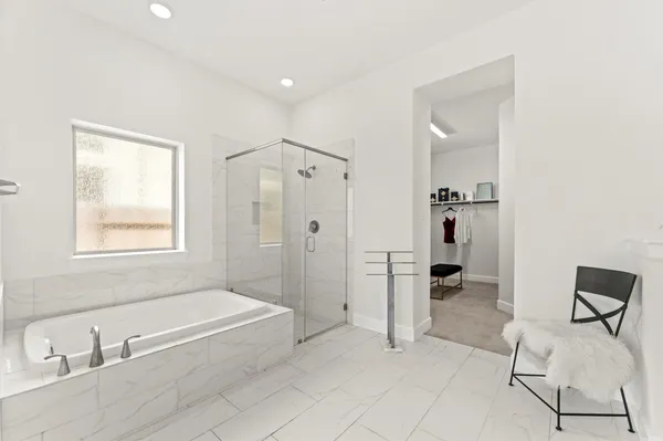 a spacious bathroom with a tub shower and mirror