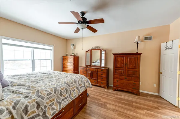 a bedroom with a bed dresser and a large window
