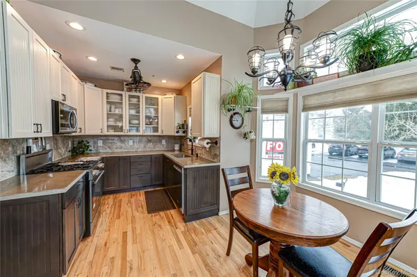 a kitchen with kitchen island granite countertop a sink a counter space appliances and cabinets