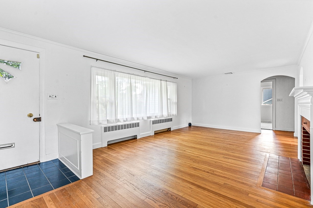 6 Old Colony Road Arlington, MA 02474 - Photo 2 of 15 a view of an empty room with wooden floor and a window