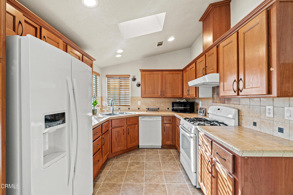 24 Via Rosal, Unit 24 Camarillo, CA 93012 - Photo 16 of 40 a kitchen with stainless steel appliances granite countertop a stove a sink and a refrigerator