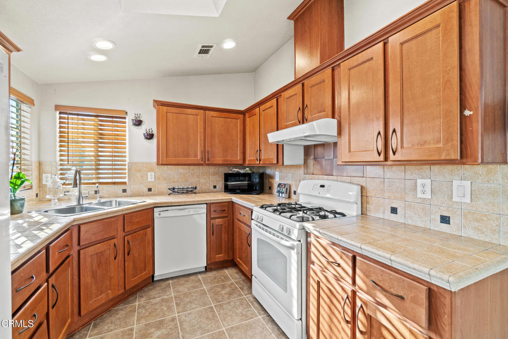 24 Via Rosal, Unit 24 Camarillo, CA 93012 - Photo 18 of 40 a kitchen with stainless steel appliances granite countertop a stove a sink and a microwave