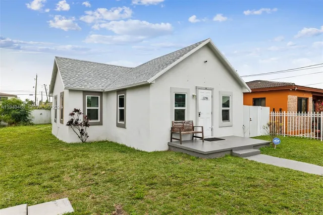 a view of a house with backyard and sitting area
