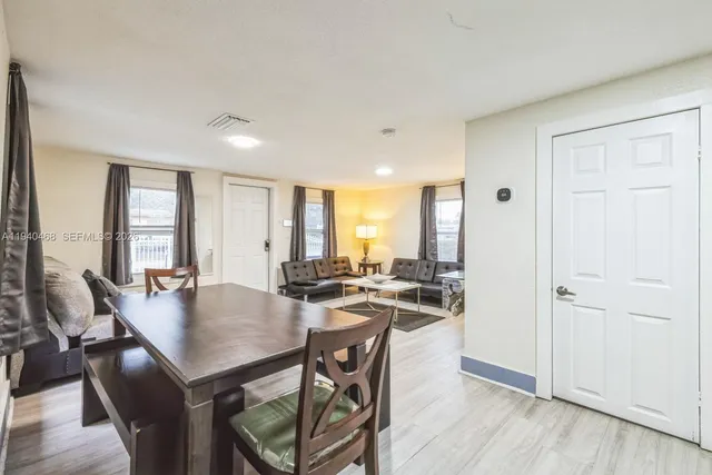 a view of a dining room and livingroom with furniture window and wooden floor