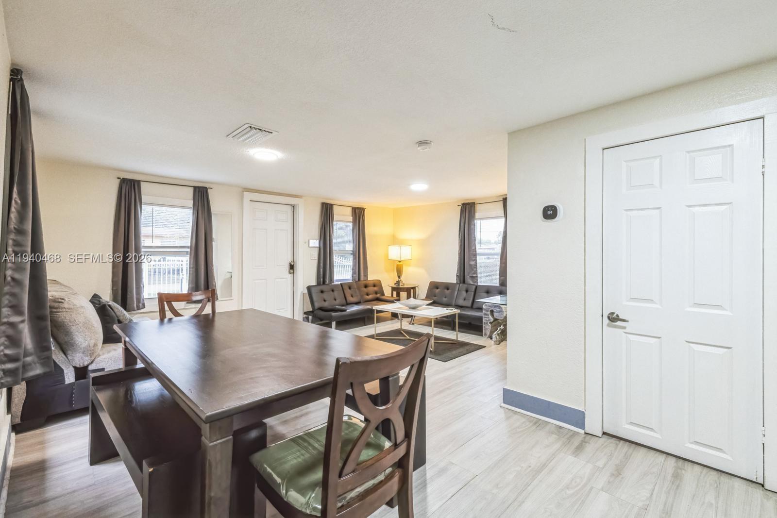1296 Northwest 72nd Street Miami, FL 33147 - Photo 11 of 12 a view of a dining room and livingroom with furniture window and wooden floor