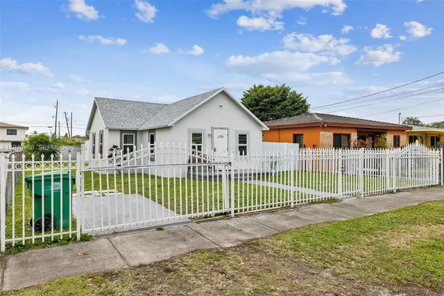 a view of a house with a wooden deck and a yard
