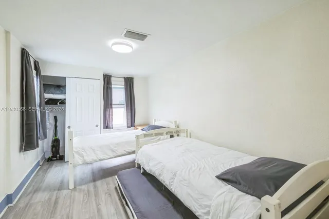 a spacious bedroom with a bed and a wooden floor